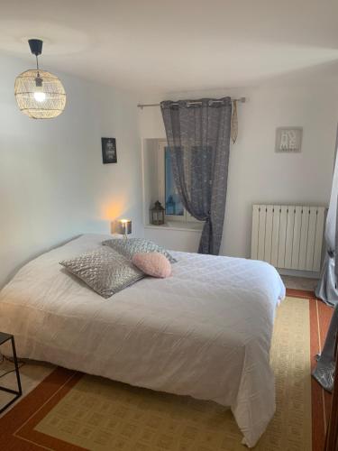 a bedroom with a large white bed and a window at La maison bleue in Remoncourt