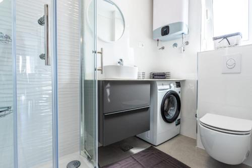 een badkamer met een wastafel en een wasmachine bij Ferienhaus MAESTRAL - Kastel Kambelovac in Kaštela