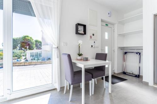 een witte tafel en stoelen in een kamer met een raam bij Ferienhaus MAESTRAL - Kastel Kambelovac in Kaštela