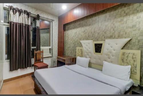 Un dormitorio con una gran cama blanca y una ventana en HOTEL Royal Plaza en Chandigarh