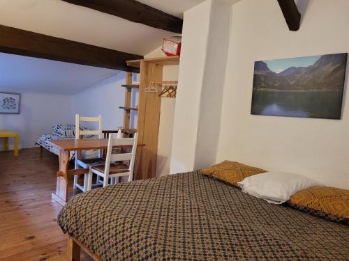 - une chambre avec un lit, une table et un bureau dans l'établissement Grande maison de montagne rénovée, du charme, à Rodome