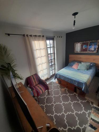 a bedroom with a bed and a chair at Katsbarnea Hostel in Florianópolis