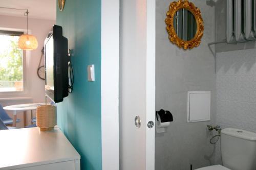 a bathroom with a toilet and a mirror on the wall at Apartament EL Romano in Gdynia