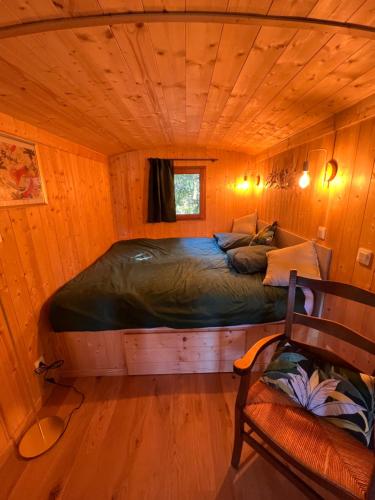 een slaapkamer met een bed in een houten kamer bij La Garenne Saint Germain in Saint-Germain-de-Marencennes