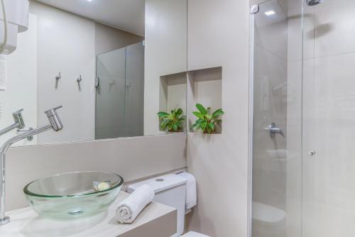 a bathroom with a glass bowl sink and a shower at Cais da Praia Hotel in Maceió