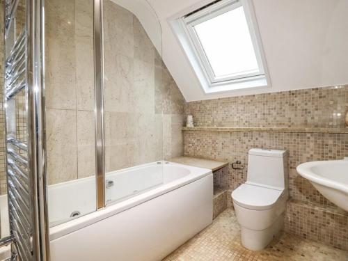 a bathroom with a tub and a toilet and a sink at Padstowgetaways in Padstow