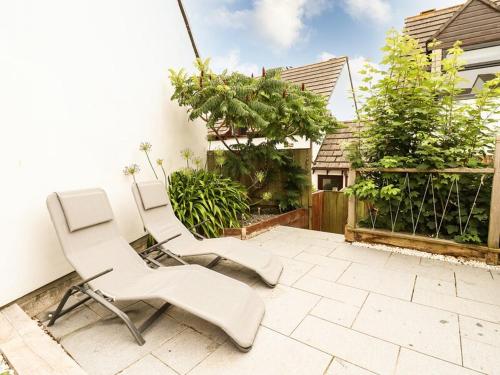two white chairs are sitting on a patio at Padstowgetaways in Padstow