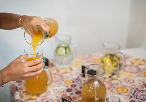 a person pouring a drink into a glass on a table at Le Querce Farmhouse in Agropoli