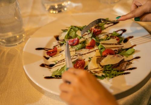 a person eating a salad on a white plate at Le Querce Farmhouse in Agropoli