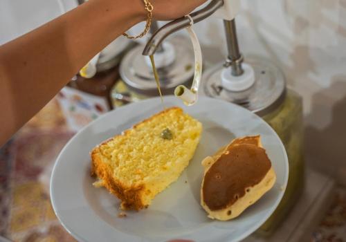 a person holding a plate with a piece of cake at Le Querce Farmhouse in Agropoli