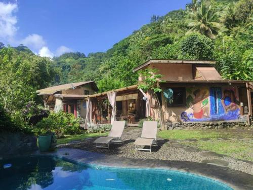 a house with a swimming pool next to a mountain at Soul Rise in Taravao