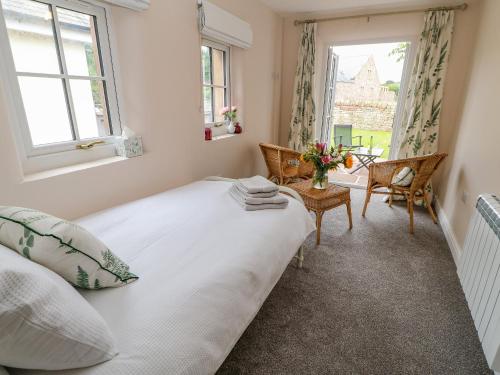 1 dormitorio con 1 cama blanca y 2 ventanas en 3 Eden View, en Penrith