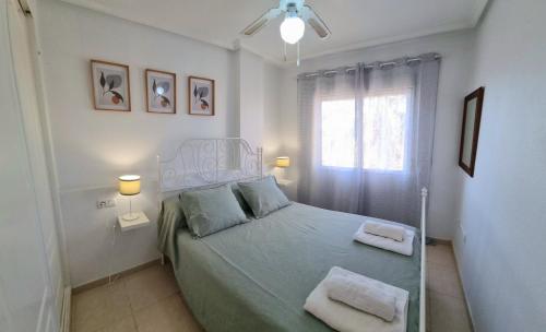 1 dormitorio con 1 cama con 2 toallas en Lovely 2 bed, 2 bath apt with 2 large pools, en Los Alcázares