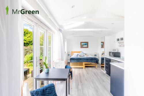 een witte kamer met een bed en een tafel bij Wick Studio in Christchurch