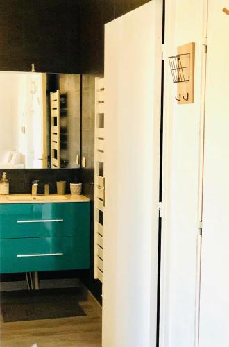 - une cuisine avec une armoire verte et un évier dans l'établissement Superbe studio 5 min de la plage, à La Grande Motte