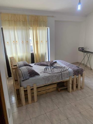 a wooden bed in a room with a window at Appart Hotel Belvedere in Praia