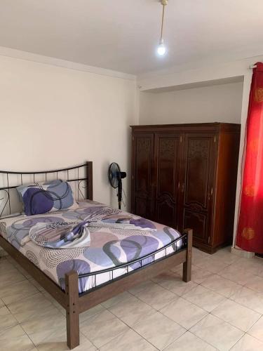 a bedroom with a bed and a wooden cabinet at Appart Hotel Belvedere in Praia