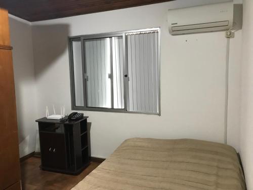 um quarto com uma cama e uma janela em Confortable espacio en Minas em Minas