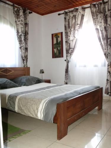 a bedroom with a large bed with drapes at Iarimbato Hotel in Antananarivo