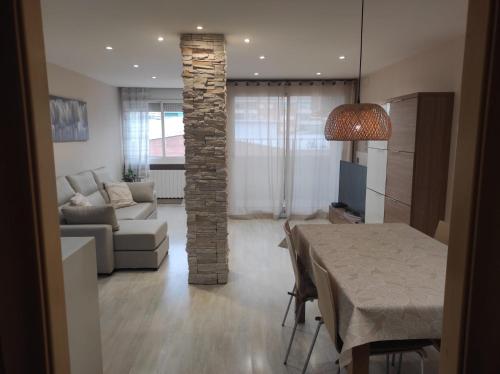 a living room with a table and a stone pillar at Apartamento en Viladecans cerca del aeropuerto in Viladecáns