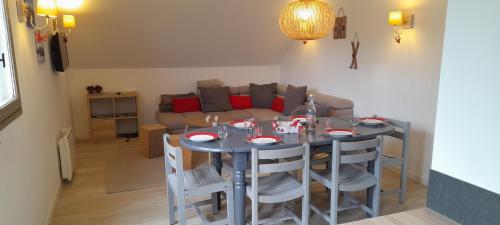 une salle à manger avec une table, des chaises et un canapé dans l'établissement Appartement 6 personnes station de ski Val Louron, à Val Louron