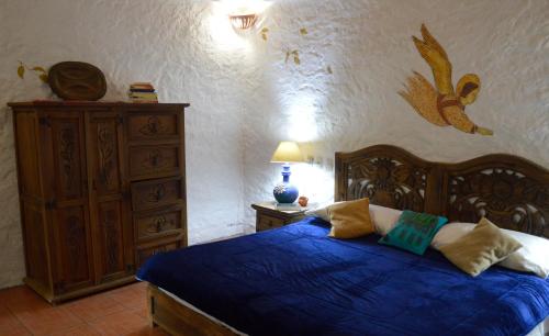 1 dormitorio con 1 cama azul y vestidor en Casa Centeopan, en Amatlán