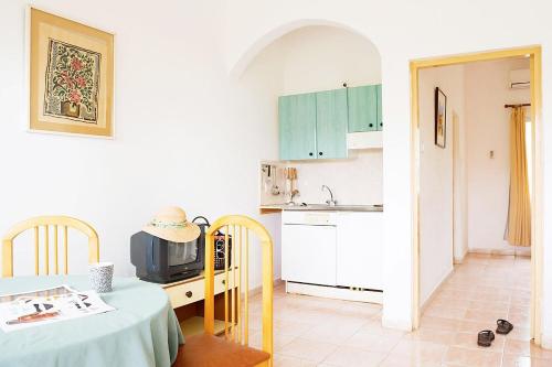 a kitchen with a table and a kitchen with a microwave at Cape Point Hotel in Bakau