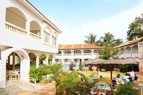 Ein Resort mit einer Terrasse mit Sonnenschirmen und einem Gebäude in der Unterkunft Cape Point Hotel in Bakau