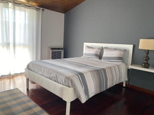 ein Schlafzimmer mit einem großen Bett mit blauer Wand in der Unterkunft BAIRRADA SUITE HOUSE BY HOTEL PARAISO in Oliveira do Bairro