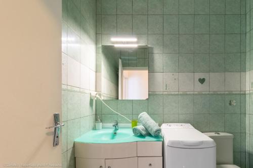 uma casa de banho com um lavatório, um WC e um espelho. em ZenBNB - L'émeraude - Beautiful Studio Apartment - Near Tram Station for Geneva em Annemasse