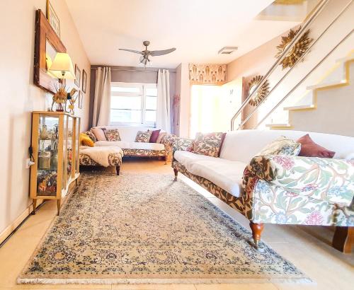 een woonkamer met 2 banken en een tapijt bij Deluxe Home from Home in Caleta de Fuste in Caleta De Fuste