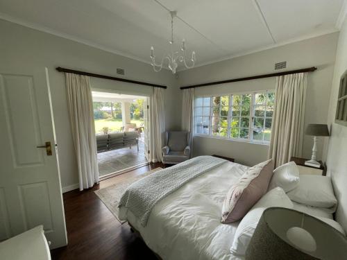 a bedroom with a bed and a large window at Protea Manor in George