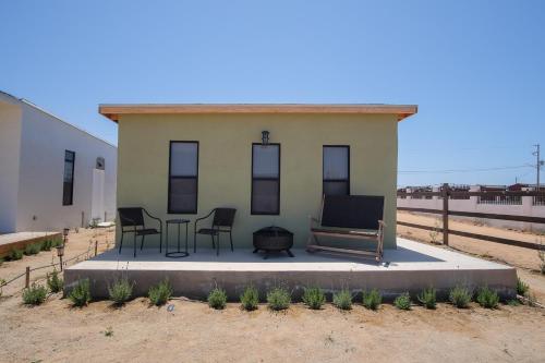 a small house with a bench and a table and chairs at Finca San Sebastian in Valle de Guadalupe