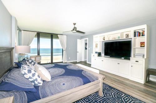 1 dormitorio con 1 cama y TV grande en Sand Dollar 1-506, en St. Augustine