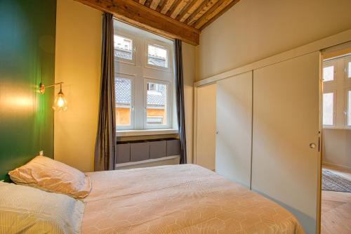 a bedroom with a bed and two windows at Standing, élégance, appartement d'architecte in Lyon
