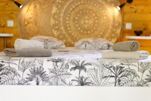 a bed with towels on top of it at Résidence Mapou : Bungalow Cycas - logement de charme avec piscine in Saint-François