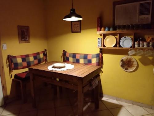 une cuisine avec une table en bois et deux chaises dans l'établissement Catamarca Cabañas Star, à San Isidro