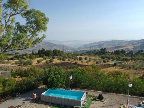 a swimming pool in the middle of a hill with a view at L'Albero Amico in Racalmuto