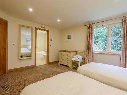 a bedroom with two beds and a mirror at Swandown, 2 Blackdown in Chard