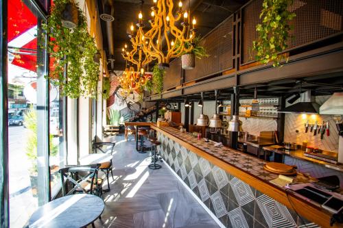 a restaurant with a long bar with a chandelier at Hotel Philosophy in Amman