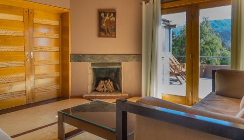 a living room with a fireplace and a couch at Las Marías Hotel Boutique in Tilcara