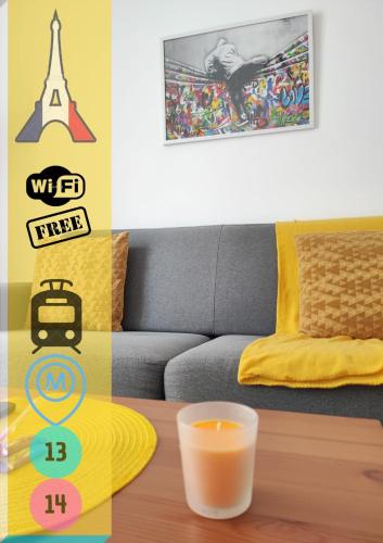 a room with a couch and a table with a cup of orange juice at *Street Clichy Art* - Appartement à 200 m de Paris ! in Clichy