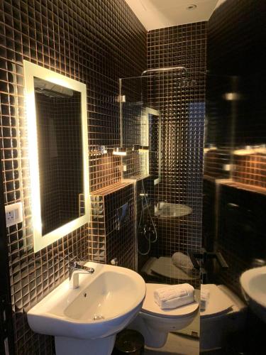 a bathroom with a sink and a toilet and a mirror at Hotel Philosophy in Amman