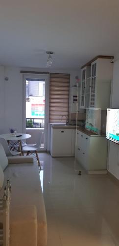a kitchen with white cabinets and a table and a window at Apartament Vila Brana Sibiu Selimbar str Nicolae Brana Nr 63 Ap 4 in Şelimbăr
