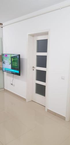 a white room with a tv and a door at Apartament Vila Brana Sibiu Selimbar str Nicolae Brana Nr 63 Ap 4 in Şelimbăr