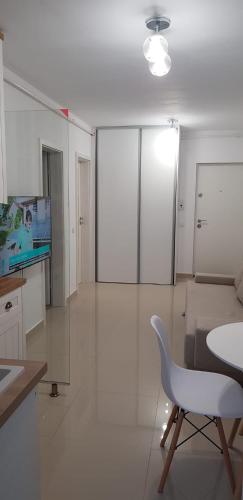 a white living room with a table and a chair at Apartament Vila Brana Sibiu Selimbar str Nicolae Brana Nr 63 Ap 4 in Şelimbăr