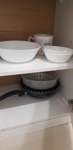 a shelf with two bowls and plates on it at Apartament Vila Brana Sibiu Selimbar str Nicolae Brana Nr 63 Ap 4 in Şelimbăr