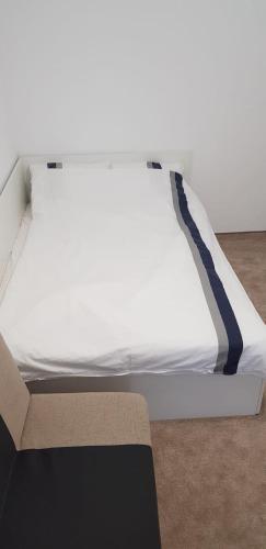 a white bed with a blue stripe on it at Apartament Vila Brana Sibiu Selimbar str Nicolae Brana Nr 63 Ap 4 in Şelimbăr