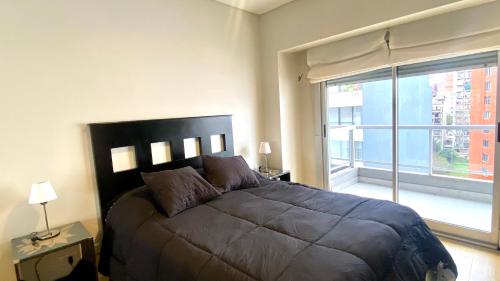 1 dormitorio con cama grande y ventana grande en ESTUDIO BORGES en Buenos Aires
