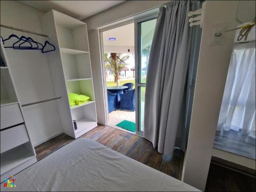 a bedroom with a bed and a sliding glass door at Best location of the development, ground floor seafront in Porto De Galinhas
